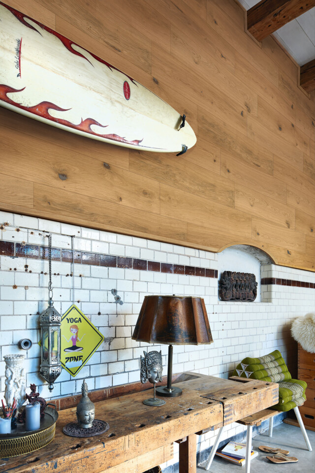 Natürliche Holzpaneele halbhoch an einer Wand mit aufgehängtem Surfbrett