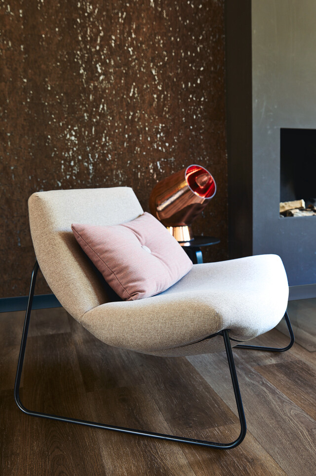 Deko-Accessoires aus Kupfer Dunkler MEISTER Laminatboden unter einem hellen Sessel