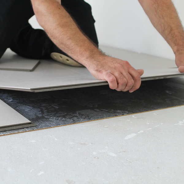 Schwimmend verlegter Parkettboden mit edelstahlfarbener Fußleiste als Detailaufnahme